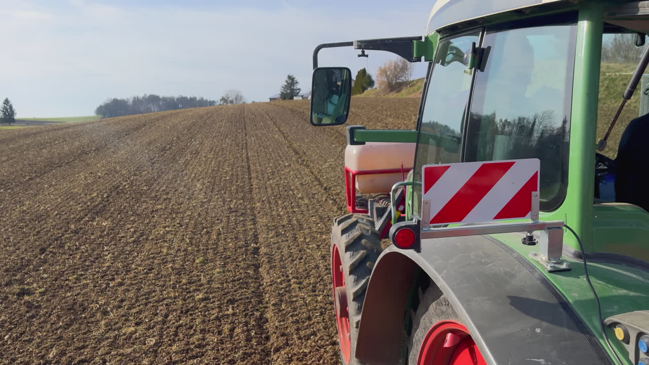 tractor gigante conduciendo sobre un campo agrícola en un día soleado