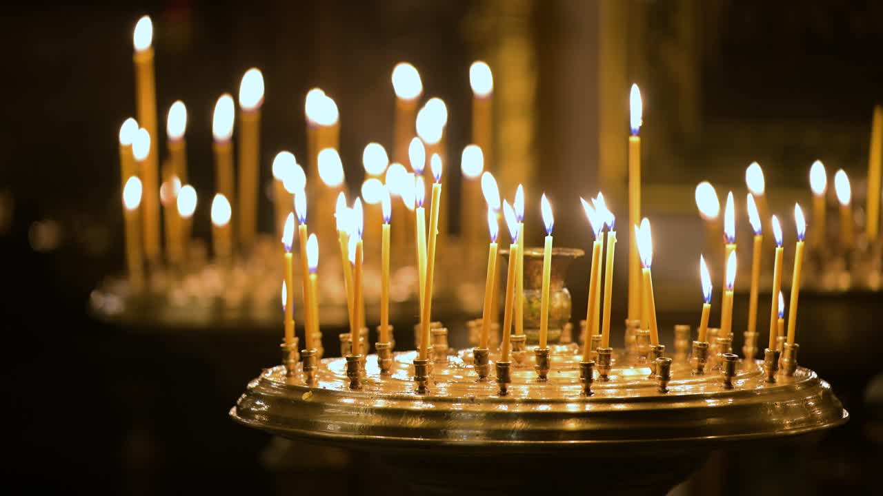 Flickering candlelight illuminates the sacred interior of St. Volodymyr's Cathedral in Kyiv, Ukraine. Votive candles offer prayers for hope and peace inside the historic Orthodox landmark.