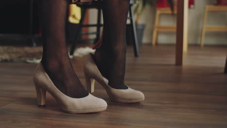 legs of transgender man putting on heels