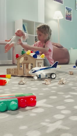 toddler builds constructor while girl playing with baby doll. concentrated kids enjoy toys in nursery view through clearance in bunch of pencils in glass