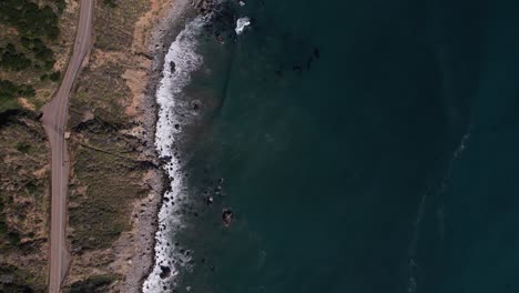 aerial drone overhead view of a car driving on highway 1 near big sur, california