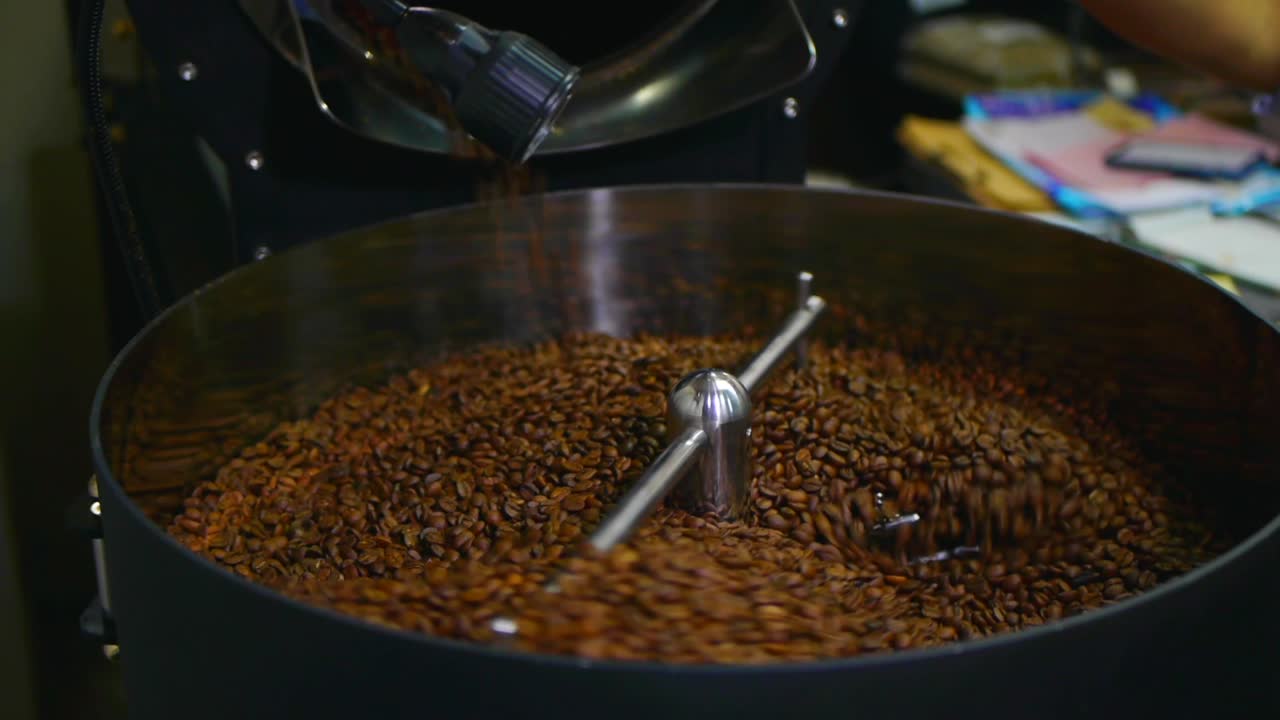 Chicchi di caffè appena tostati versati in una piastra di raffreddamento per il raffreddamento tramite agitazione