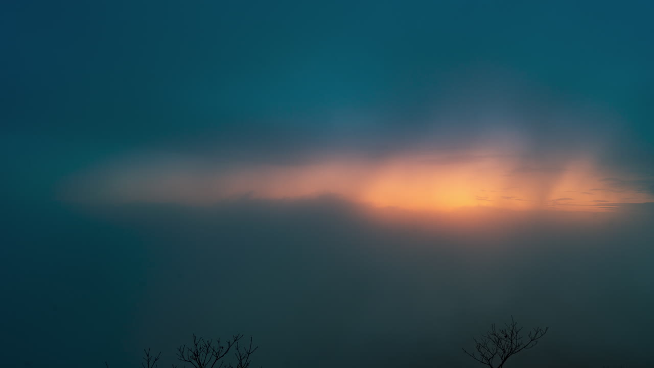 해가 뜨는 동안 산을 통과하는 안개와 구름
