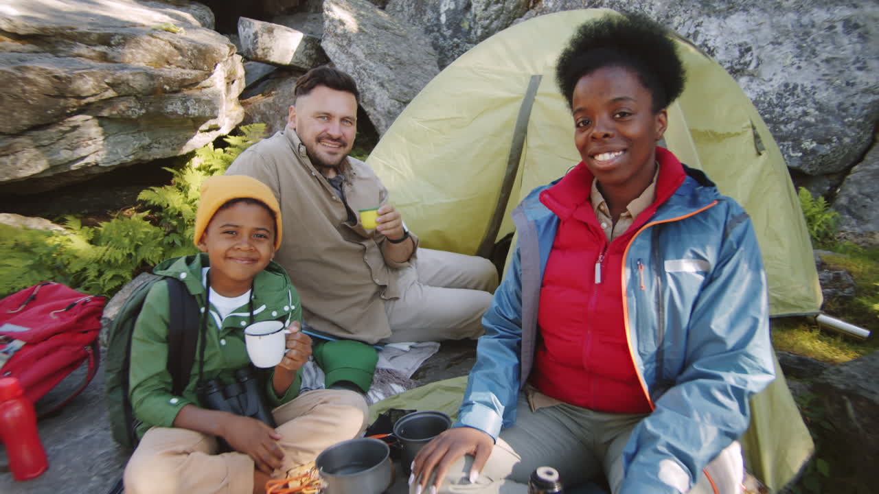 Portrett av lykkelig flerkulturell familie på campingplass