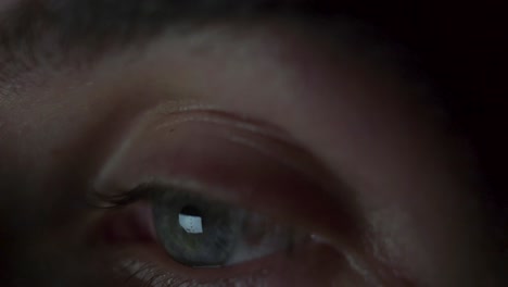 primer plano macro del ojo de un hombre abriéndose, mirando a su alrededor y mirando su teléfono