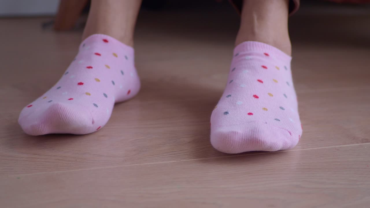 나무 바닥에 분홍색 폴카 점 양말