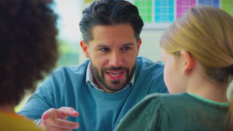 close up of male teacher talking with group of multi-cultural students in classroom lesson