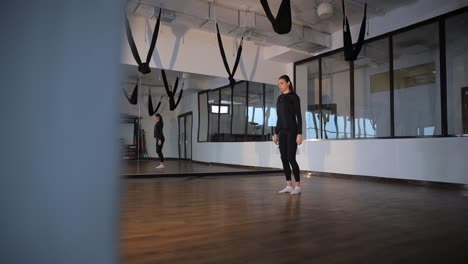 a woman practicing aerial yoga and fitness exercises in a gym