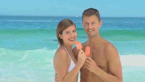 sweet couple eating water ices with their backs to the sea