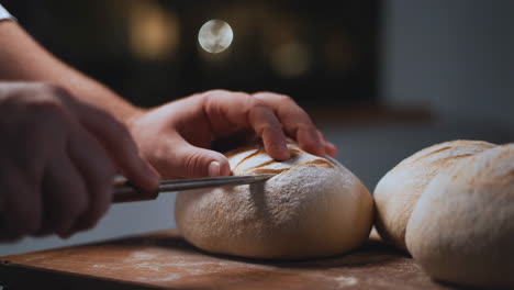 Close-up of a Baker Scoring a Loaf of Dough