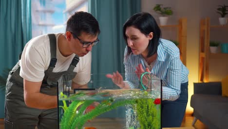 close up serving aquarist advises a young woman about the aquarium at home