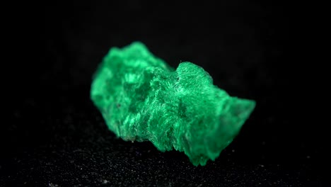 la rotación sin problemas de un mineral verde (malaquita) frente a un fondo negro