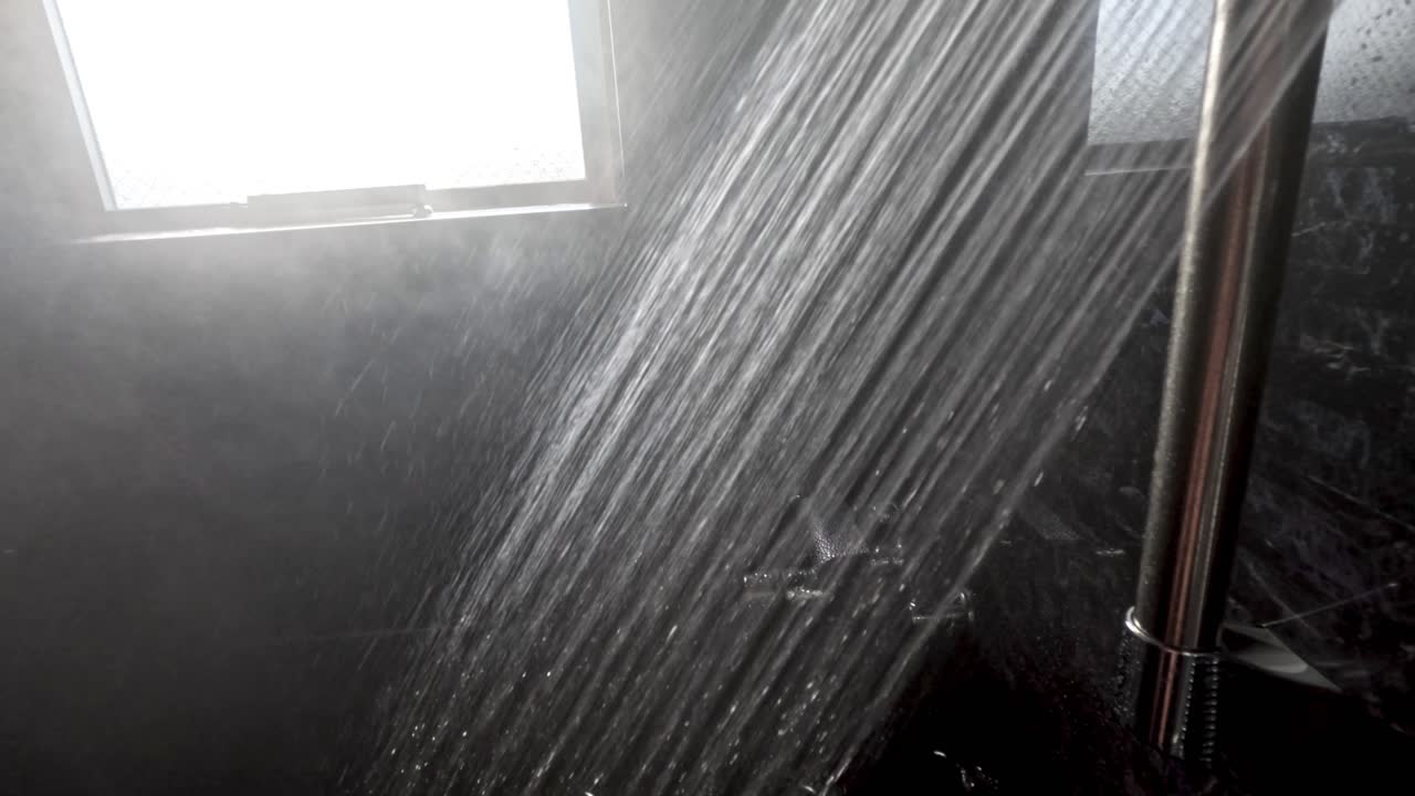 Water flowing from showerhead in bathroom