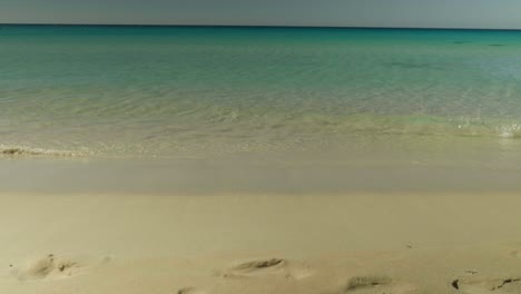 vibrant blue ocean waves crashing on a pristine white sandy shore, creating a soothing, natural coastal scene.