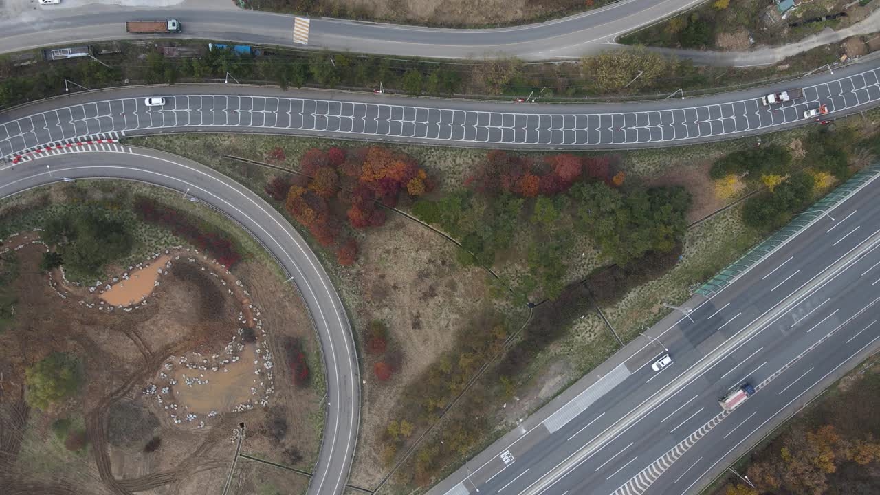 루프 모양의 교통 교차로와 가을의 나무 위쪽에서 공중에서 볼 수 있습니다.