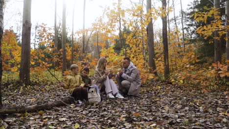 familie sitzt um einen toten baum herum