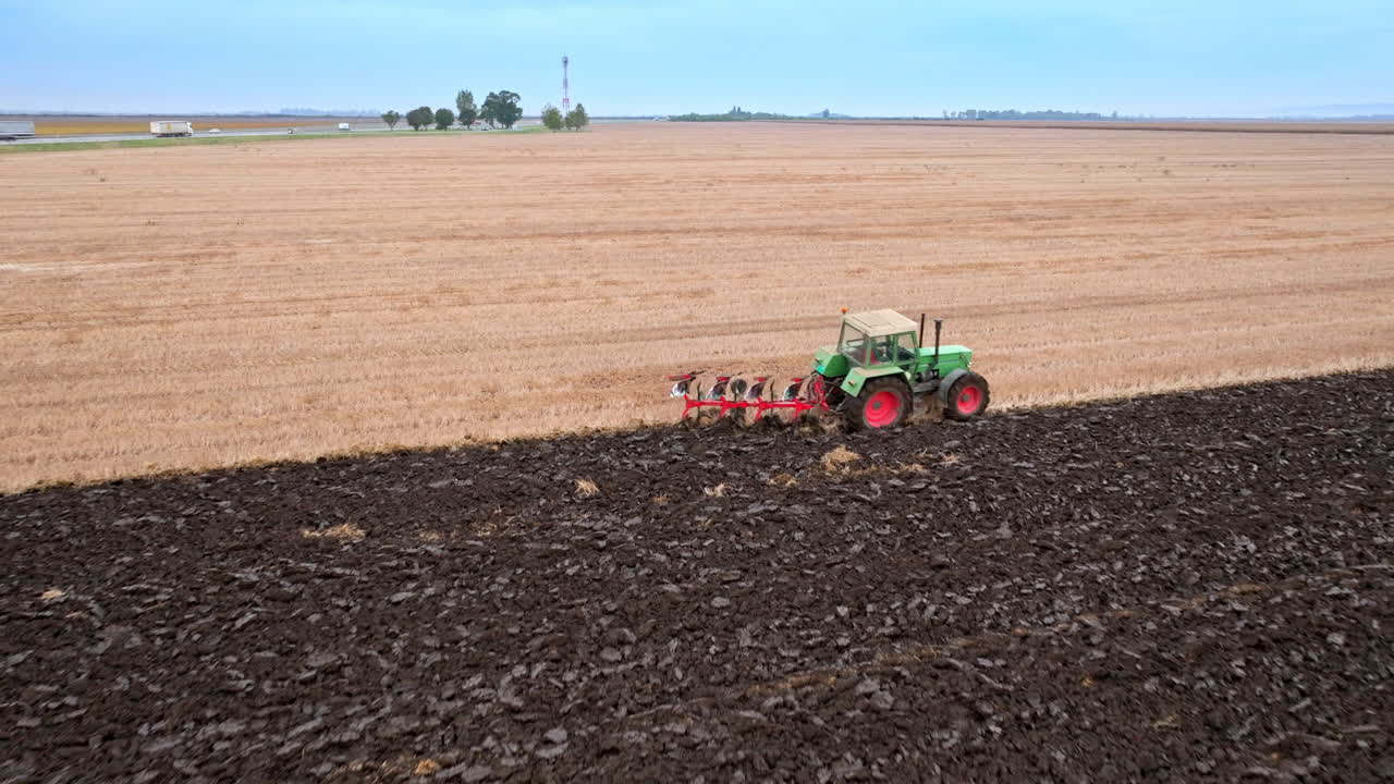 трактор вспахивает поле