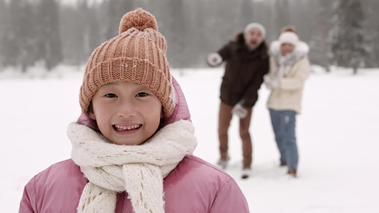 Girl smiles in winter snow scene with family