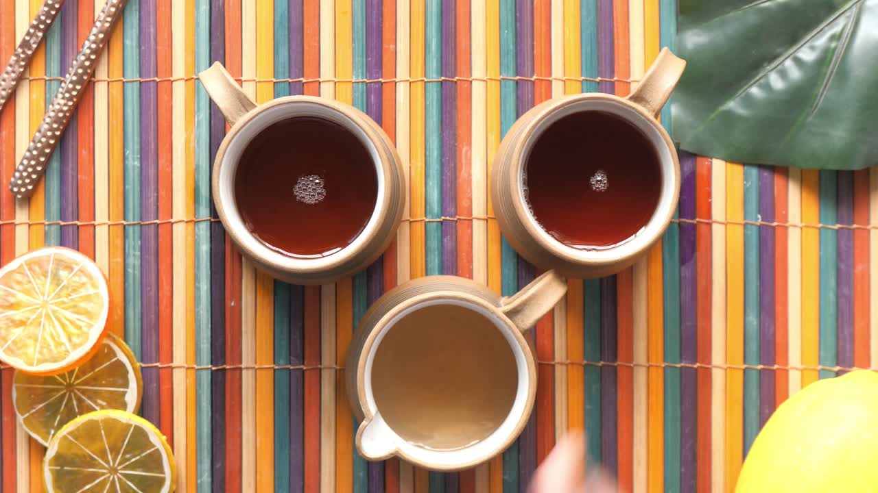 tazas de té y rebanadas de limón en una alfombra de colores
