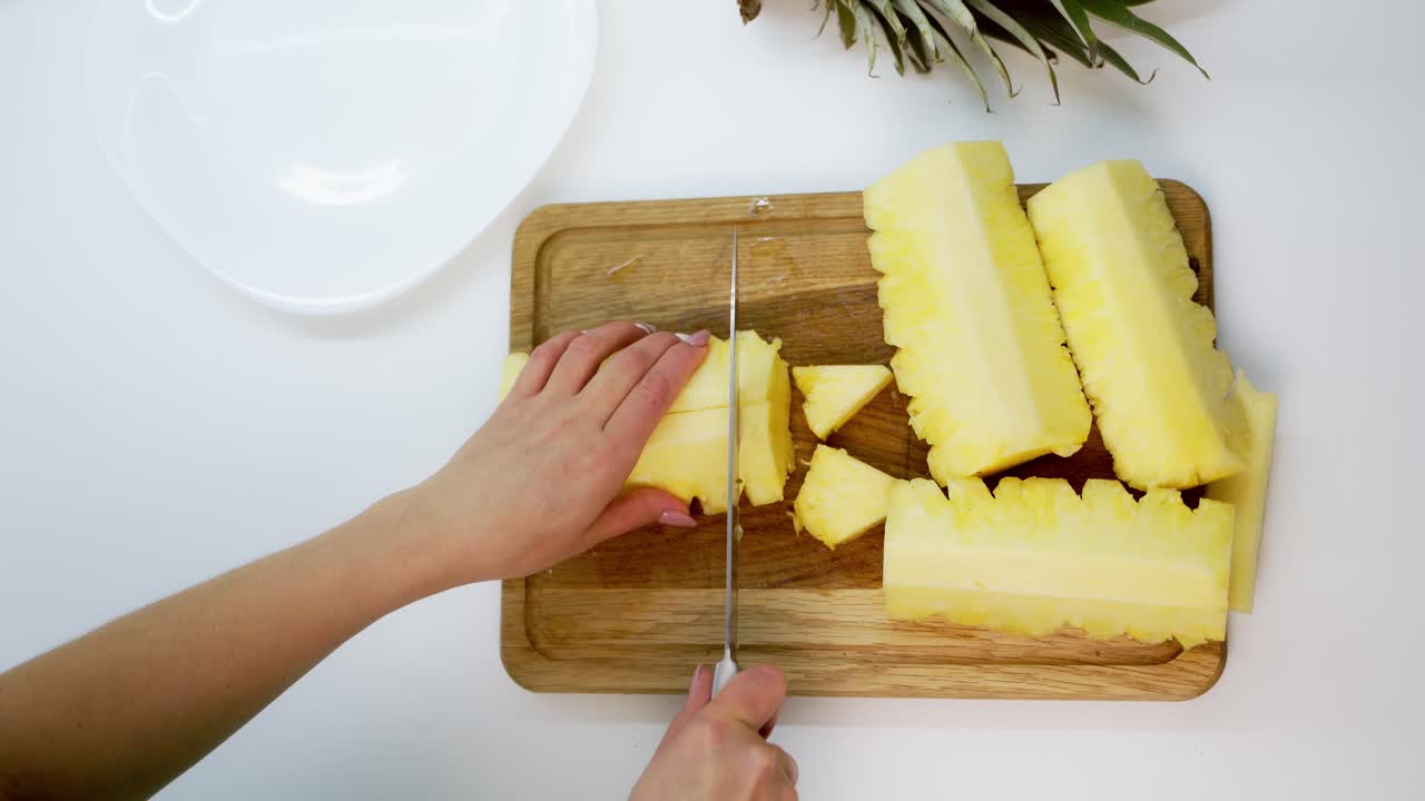 View of slices of fresh pineapple. Sliced pineapple on desk with knife isolated on white background