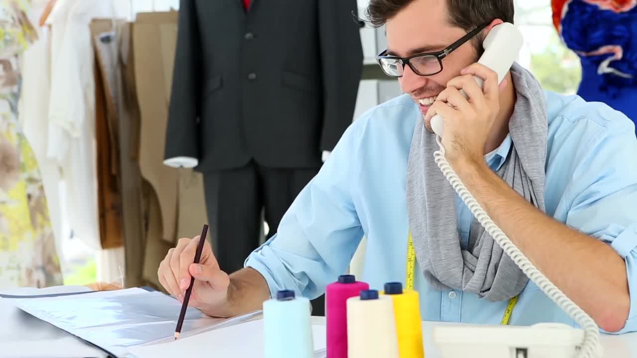 Designer che parla al telefono e poi sorride alla telecamera