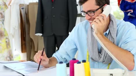 designer spricht am telefon und lächelt dann in die kamera