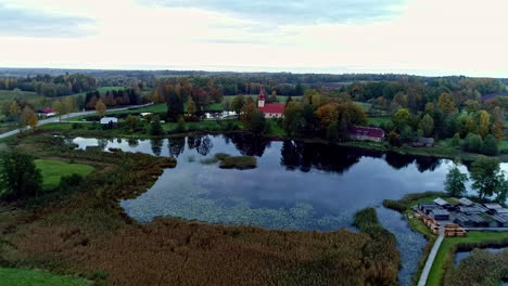 aerial backward moving shot of the āraiši lake dwelling site built on an island in the middle of āraiši lake in arheoloģiskais parks, latvia on a cloudy day