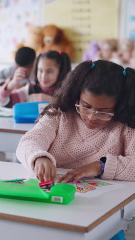 una niña coloreando en un salón de clases