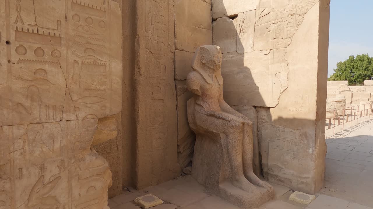 vista de la estatua del faraón sentado a la sombra en el templo de karnak en egipto