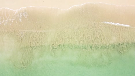 aerial top view of ocean blue waves breaking on a beach