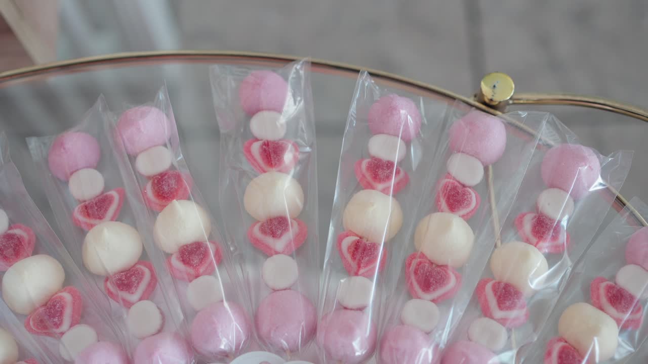 Colorful skewers with heart candy and marshmallows wrapped for a wedding treat