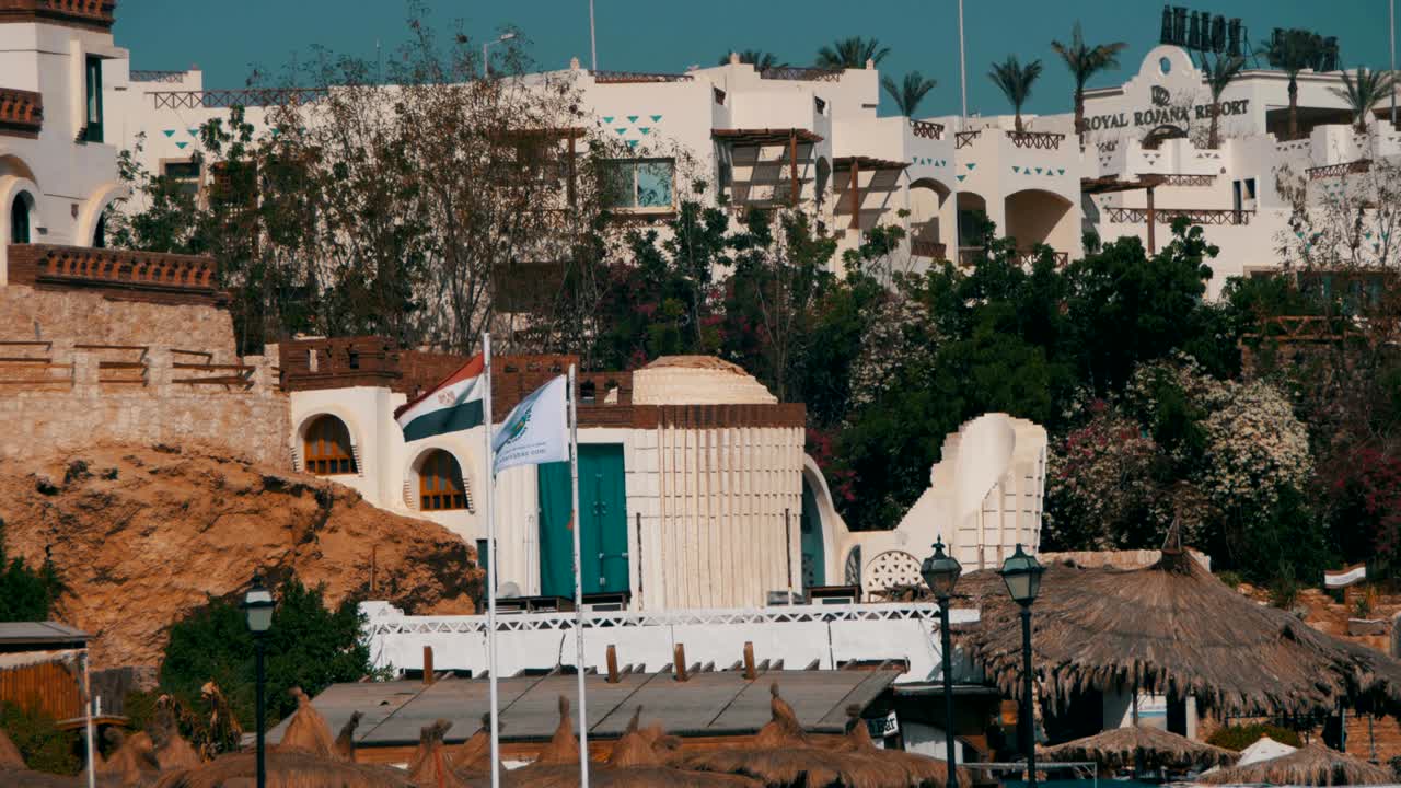 las banderas de egipto revoloteando en el mástil en el fondo de los hoteles turísticos