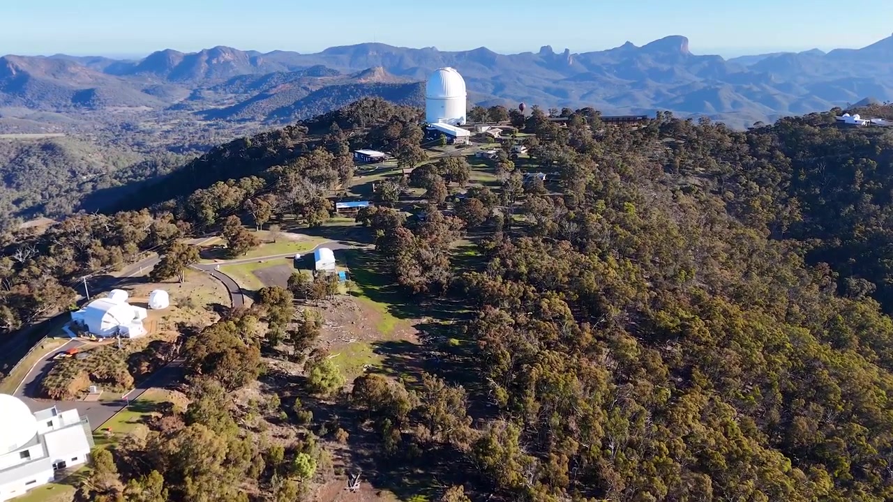 Ripresa con drone di cupole di telescopi su una cresta montuosa nel Parco Nazionale di Warrumbungle, Australia
