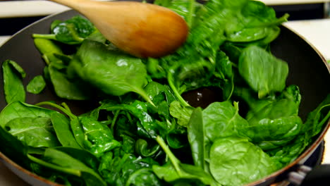 spinach sautéed in a frying pan on a stove top