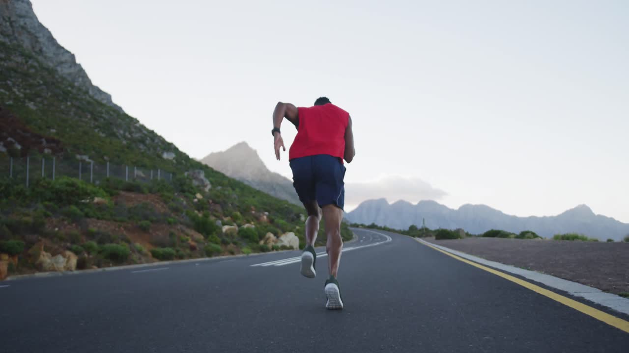 vista trasera de un hombre afroamericano corriendo por la carretera