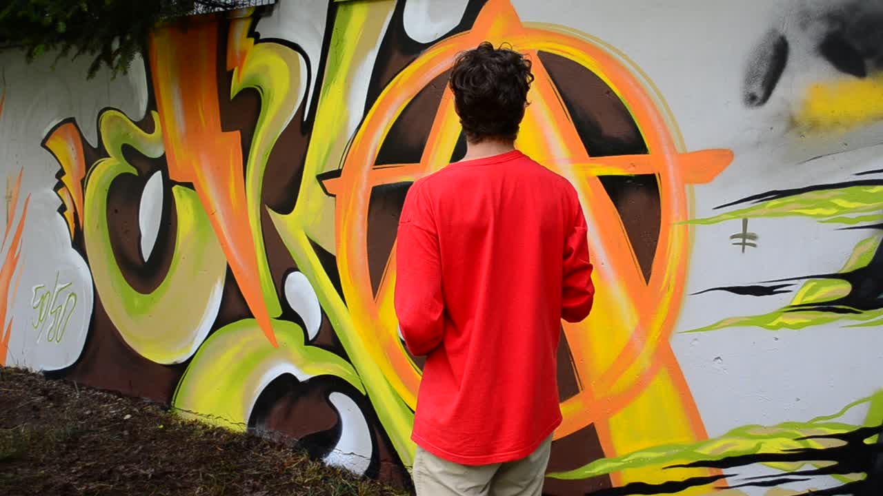 Process of creation of graffiti, fence. The artist draws graffiti