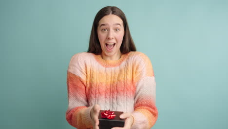 young woman receiving a gift expressing happiness