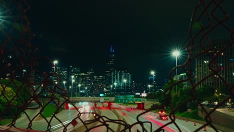 timelapse of chicago trough metal grid fence at night