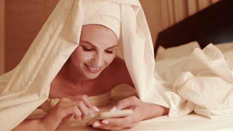 woman using phone in bed
