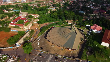 Vista-Aérea-Alejándose-De-La-Basílica-De-María-Reina-De-Los-Apóstoles,-En-El-Soleado-Camerún