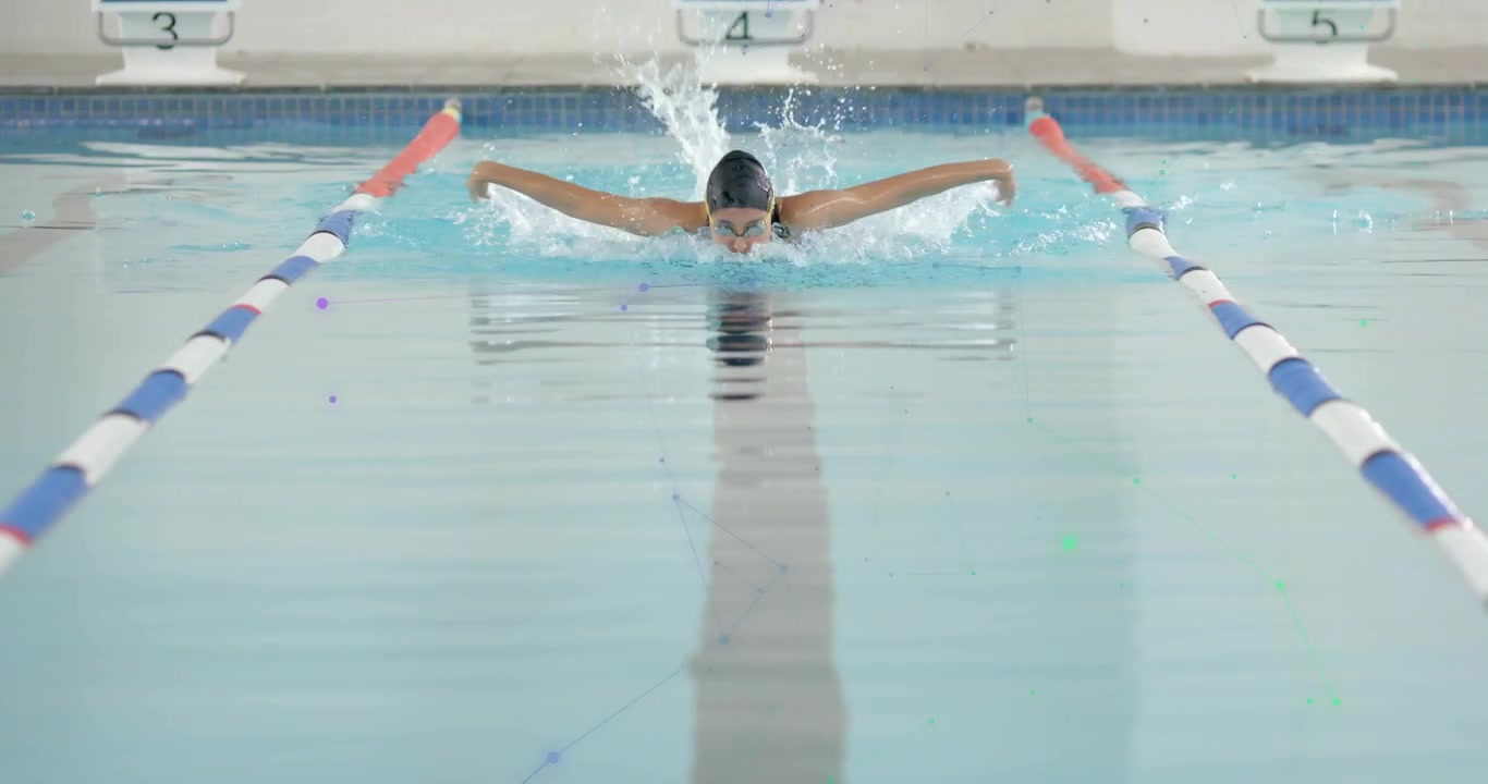 Female swimmer crossing lap midpoint and initiating strokes amid water spray for fitness training