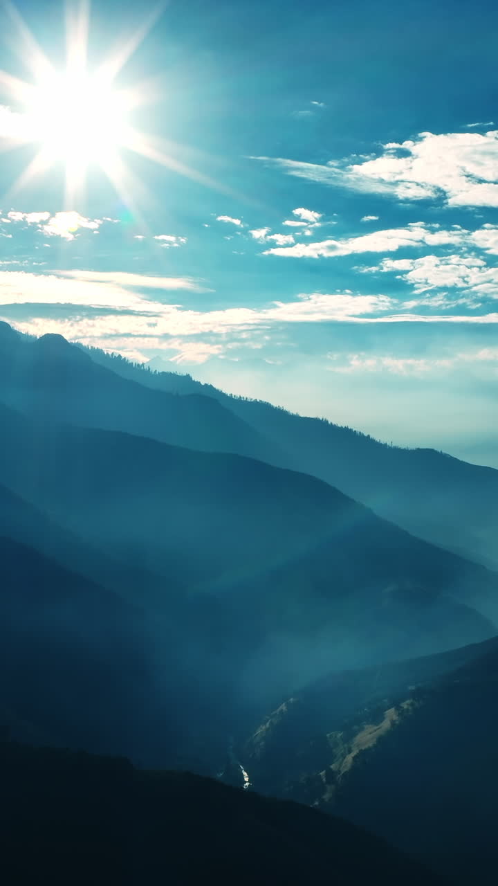 Bright sun shining above the mountains of California. Silhouettes of huge rocks in a blue haze. Vertical video