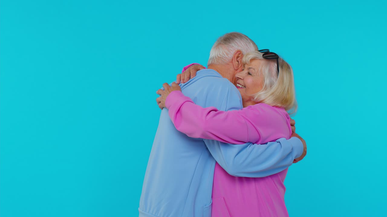 Coppia anziana romantica di nonni che si abbracciano, guardano la fotocamera e sorridono.