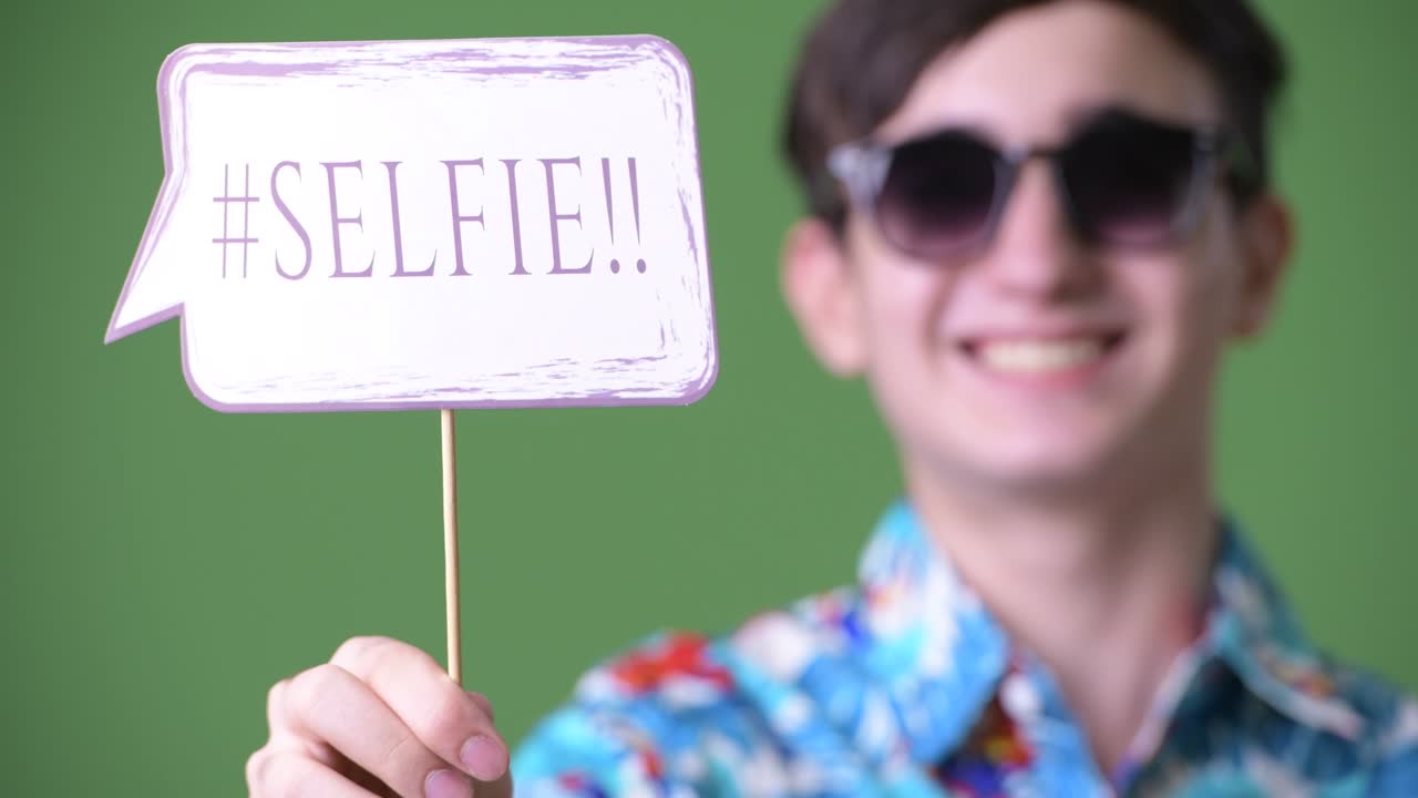 젊은 잘생긴 이란 십대 소년은 녹색 배경에 휴가를 준비