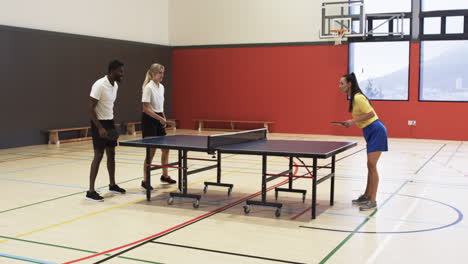 playing table tennis, students practicing in school gymnasium, focusing on game