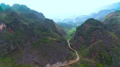 A-busy-road-of-motorcycles-cuts-through-two-mountains-among-the-misty-back-drop-in-northern-Vietnam-as