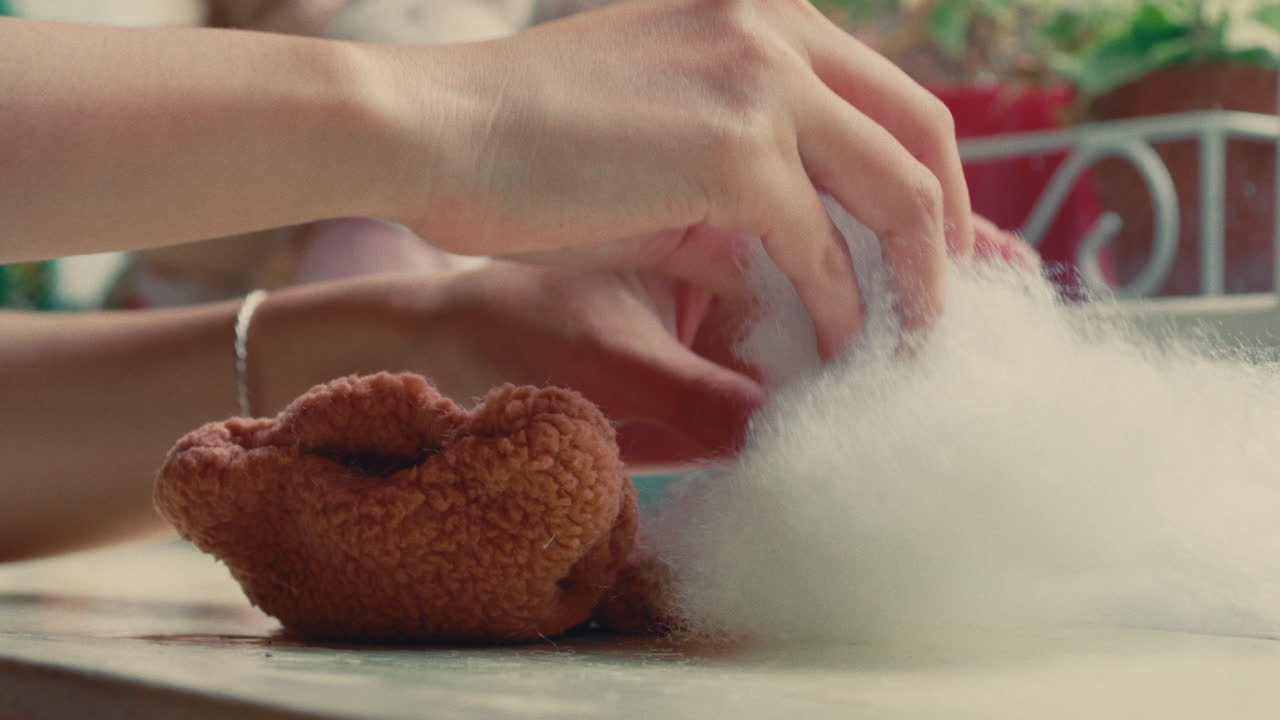 Woman crafting a teddy bear with wool fluff