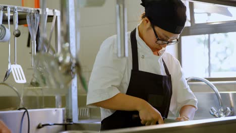 female chef cutting vegetables in kitchen 4k