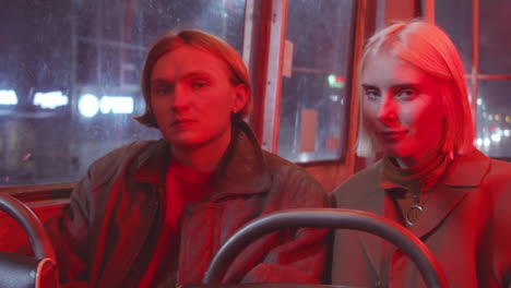 portrait of young couple riding tram in night