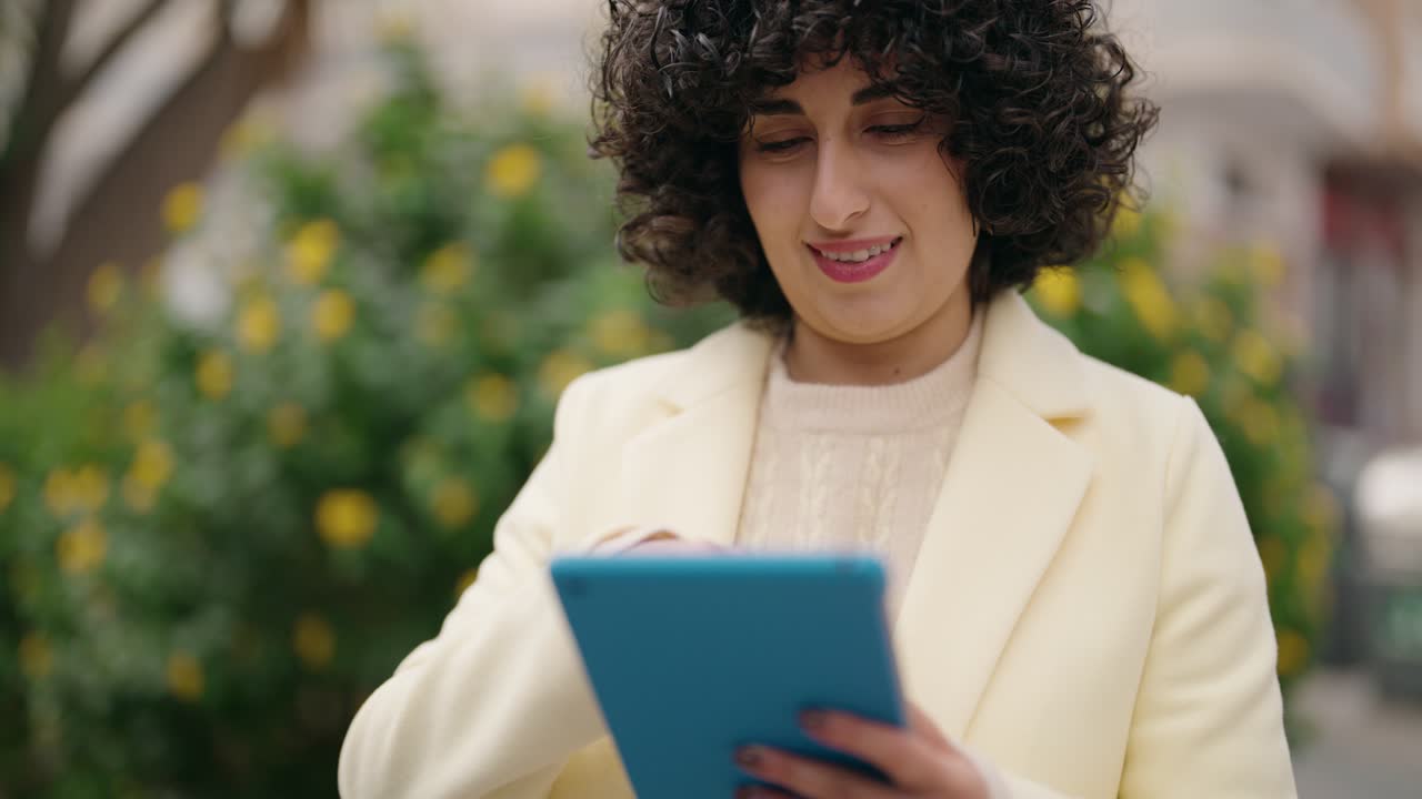 una mujer joven sonriendo con confianza usando el touchpad en el parque